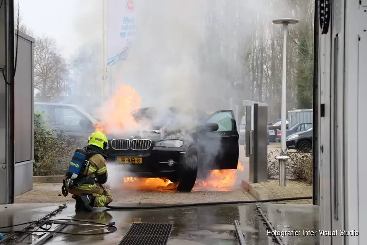 Auto in brand voor ingang wasstraat